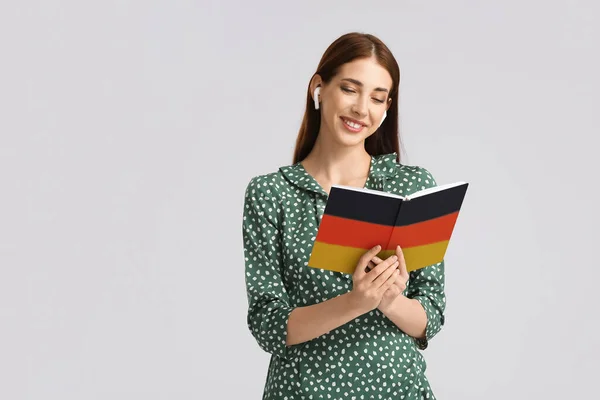 Молода Жінка Навушниками Книжкою Світлому Тлі Концепція Вивчення Німецької Мови — стокове фото