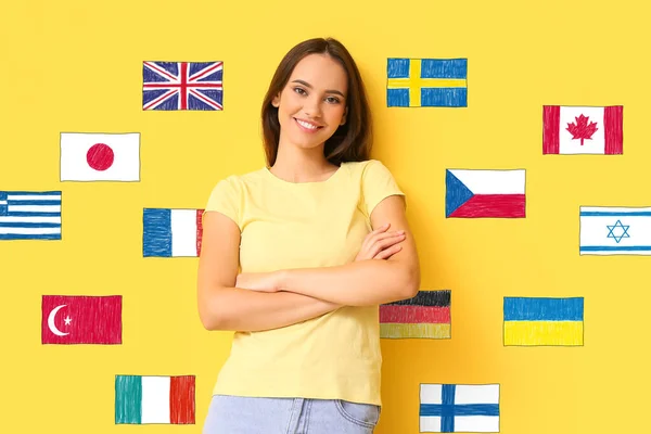 Krásná Mladá Žena Různé Vlajky Žlutém Pozadí Studium Cizích Jazyků — Stock fotografie
