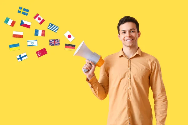 Young Man Megaphone Many Different Flags Yellow Background Studying Foreign — Stock fotografie