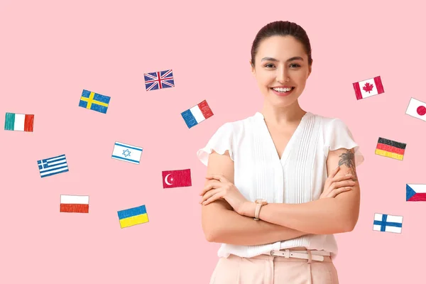 Hermosa Mujer Joven Diferentes Banderas Sobre Fondo Rosa Estudio Lenguas — Foto de Stock