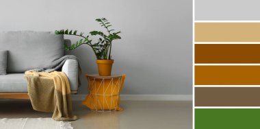 Çiçekli masa ve ışık duvarının yanındaki gri kanepe. Farklı renk desenleri