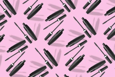 Black mascara on pink background. Pattern for design