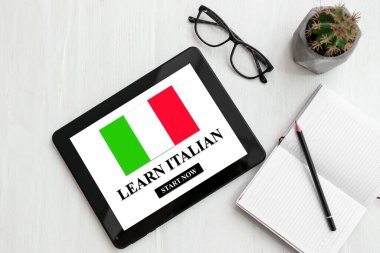 İş yerinde ekranda LEARN ITALIAN yazılı modern tablet bilgisayarı, üst görünüm