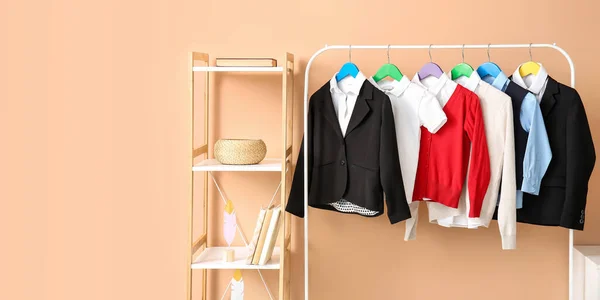 Shelf unit and rack with school uniform near color wall