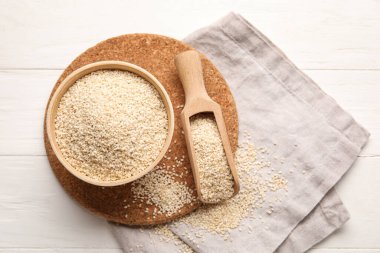 Hafif ahşap arka planda susam tohumları ile kase ve kepçe