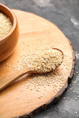 Arkaplanda susam tohumları olan ahşap tahta, yakın plan.