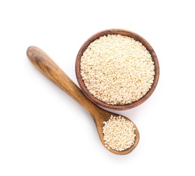 Tahta kase ve kaşık dolusu susam tohumu beyaz arka planda izole edilmiş.