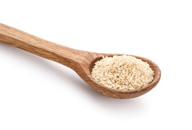 Beyaz arka planda susam tohumlu tahta kaşık, yakın plan.