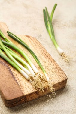 Hafif arka planda yeşil soğanlı ahşap tahta, yakın plan.