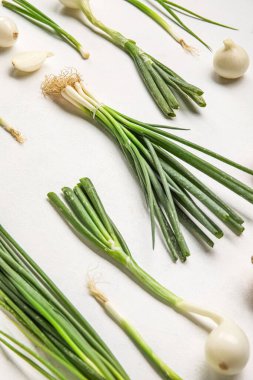 Açık arkaplanda taze yeşil soğanlı kompozisyon