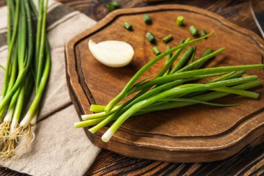 Tahta üzerinde yeşil soğan olan tahta, yakın plan.