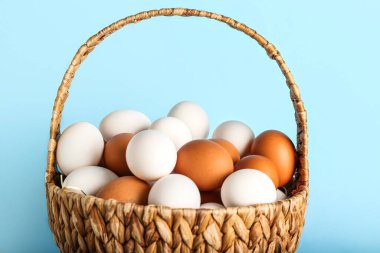 Mavi arka planda tavuk yumurtalı sepet, yakın plan.