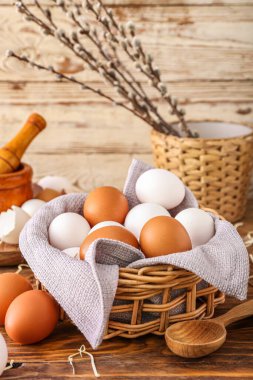 Tahta masanın üzerinde taze tavuk yumurtaları olan sepet.