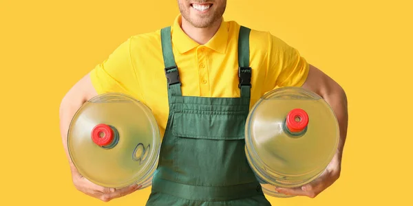 Delivery Man Bottles Water Yellow Background — Zdjęcie stockowe