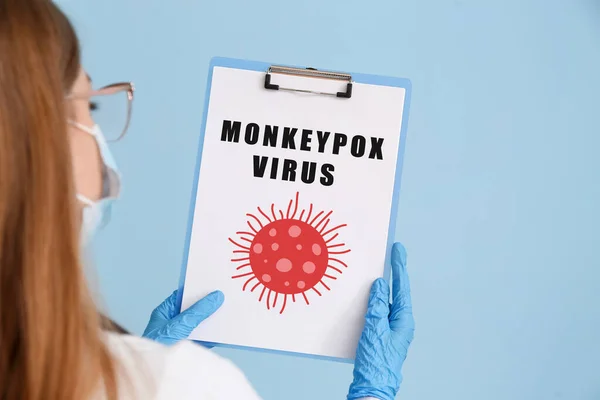 Kobieta Lekarz Trzymając Schowek Tekstem Monkeypox Virus Niebieskim Tle — Zdjęcie stockowe
