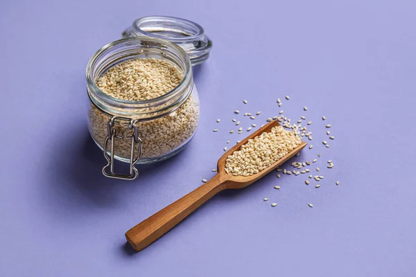 Glass Jar Wooden Scoop Sesame Seeds Color Background — Stockfoto