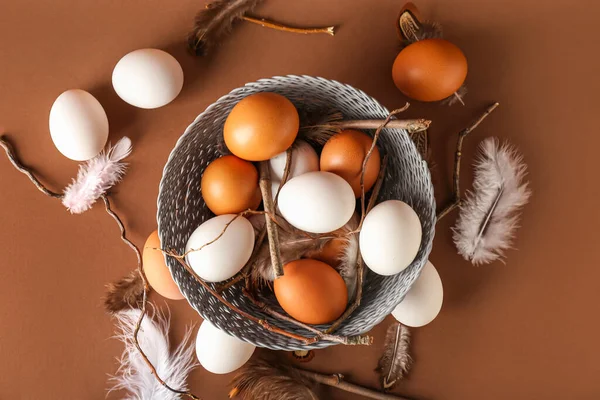 Wicker Μπολ Αυγά Κοτόπουλου Φτερά Και Κλαδιά Δέντρων Στο Φόντο — Φωτογραφία Αρχείου