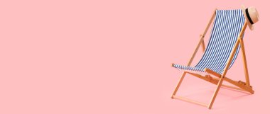 Plaj güvertesi sandalyesi ve pembe arka planda şapka. Mesaj için yer var.