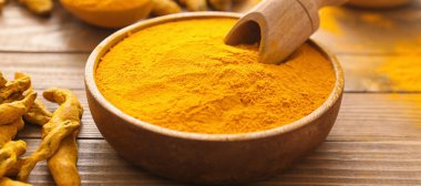 Aromatik zerdeçal ve ahşap arka planda kepçe, yakın plan