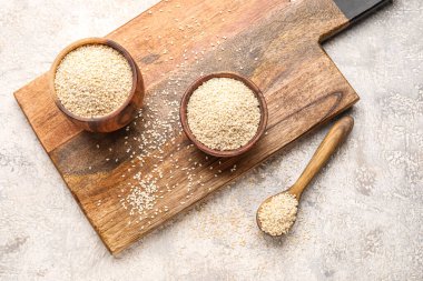 Tahta tahta tahta kaplar ve arka planda susam tohumları.