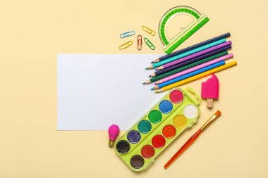 Bej arkaplan üzerine okul kırtasiyesi olan boş kağıt sayfası