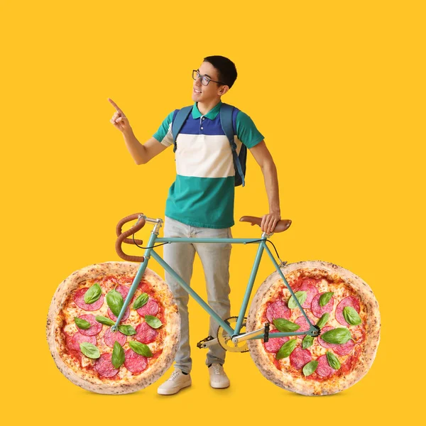 Male Asian Student Bicycle Pizza Pepperoni Instead Wheels Yellow Background — Zdjęcie stockowe