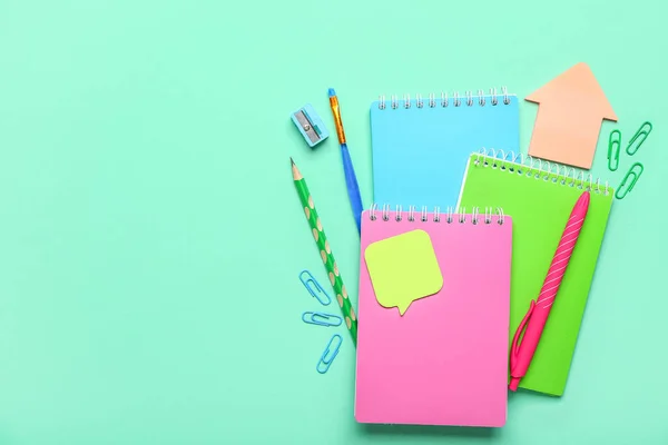 Set of stationery with notebooks on color background