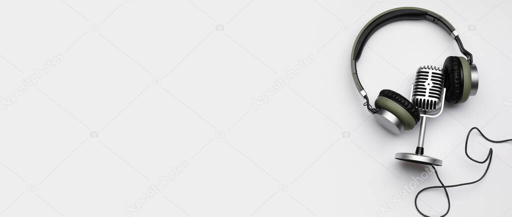 Headphones and microphone on white background with space for text