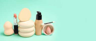 Makyaj süngerleri, ruj ve turkuaz arka plan temeli ve metin için boşluk