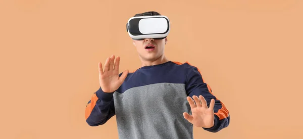 Junger Mann Mit Virtual Reality Brille Auf Beigem Hintergrund — Stockfoto