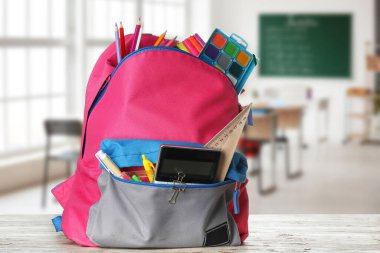 Sınıfta masada kırtasiye ile Okul sırt çantası