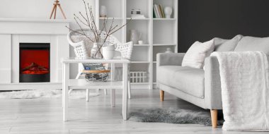 Rahat bir kanepe, koltuk ve şömineli bir masa.