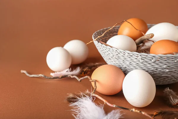 Wicker Μπολ Αυγά Κοτόπουλου Φτερά Και Κλαδιά Δέντρων Στο Φόντο — Φωτογραφία Αρχείου