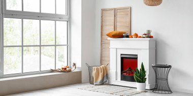 Modern şömineli ve sonbahar dekorlu bir aydınlatma odası.