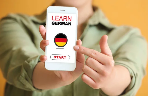 Женщина Держащая Мобильный Телефон Текстовым Уроком Немецкого Экране Крупным Планом — стоковое фото