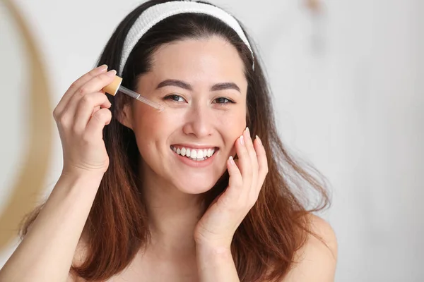 Young Asian Woman Using Cosmetic Serum Bathroom — Zdjęcie stockowe