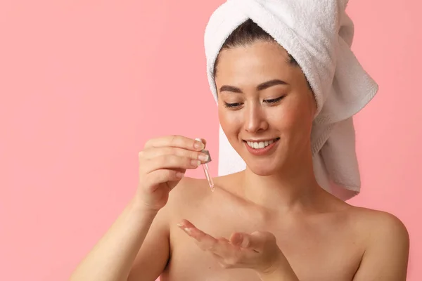 Giovane Donna Asiatica Con Siero Cosmetico Sfondo Rosa — Foto Stock