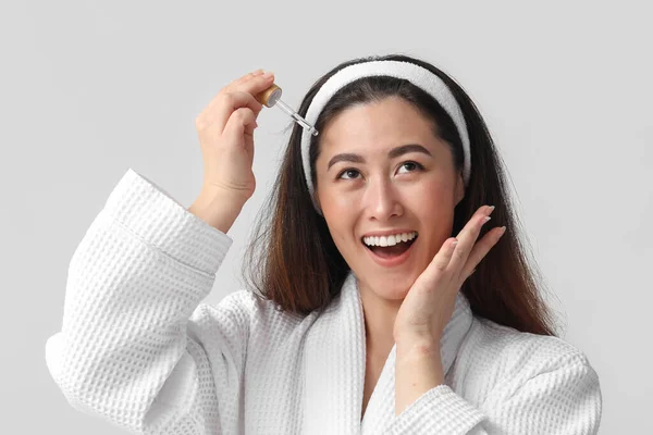 Young Asian Woman Cosmetic Serum Grey Background — Φωτογραφία Αρχείου