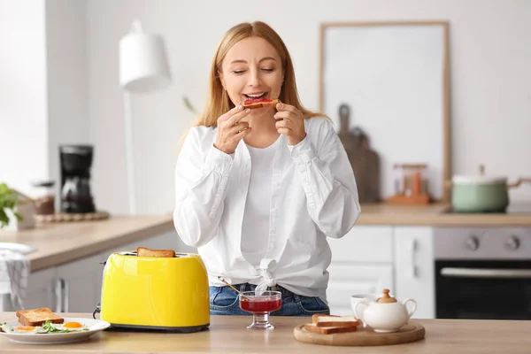 Mature Woman Eating Tasty Toasts Kitchen —  Fotos de Stock