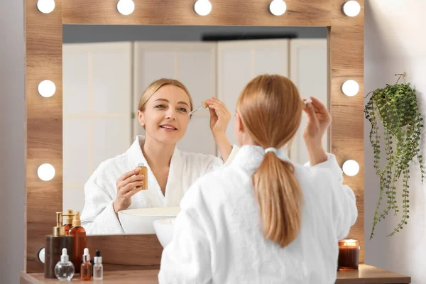 Mature Woman Using Cosmetic Serum Bathroom — ストック写真