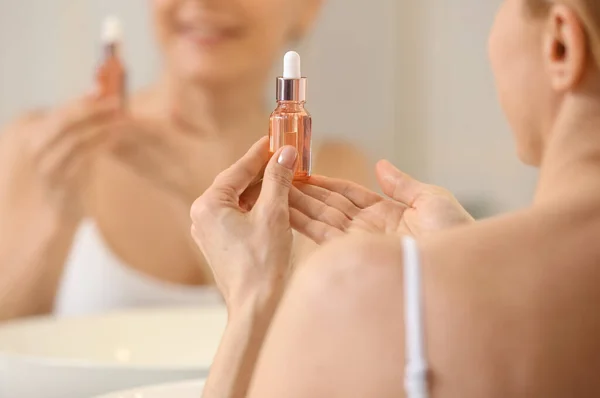 Mature Woman Using Cosmetic Serum Bathroom Closeup — Stockfoto