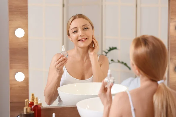 Mature Woman Using Cosmetic Serum Bathroom — Stok fotoğraf