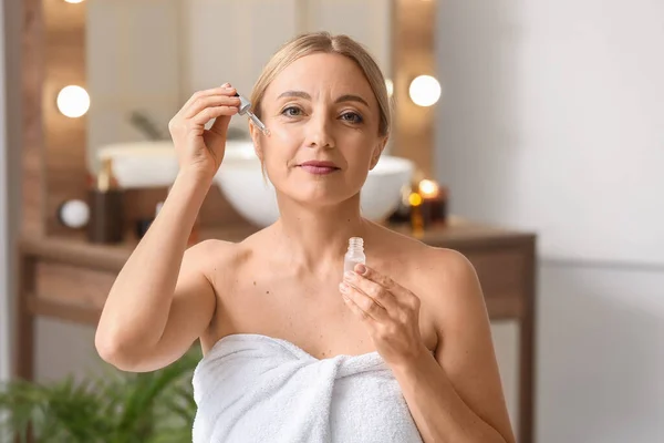 Mature Woman Using Cosmetic Serum Bathroom — Stockfoto