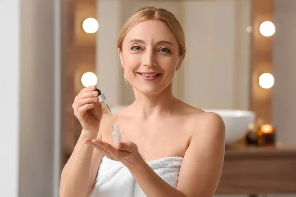 Mature Woman Using Cosmetic Serum Bathroom — Stockfoto