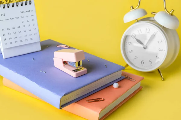 Stapler Books Alarm Clock Calendar Yellow Background Closeup — ストック写真