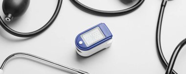 Işık arkaplan üzerinde sfenometre ve stetoskop ile nabız oksimetresi