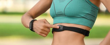 Sportif bayan koşucu nabzı kontrol ediyor, yakın plan.