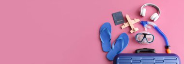 Paketlenmiş bavul ve plaj aksesuarları pembe arkaplandalar ve metin için yer var