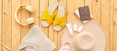 Ahşap arka planda seyahat etmek için kadın giysileri ve aksesuarlar.