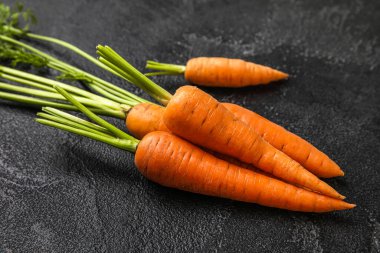 Koyu arkaplanda taze havuç, yakın plan.